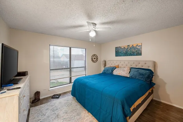 a bedroom with a bed and a flat tv screen on the dresser