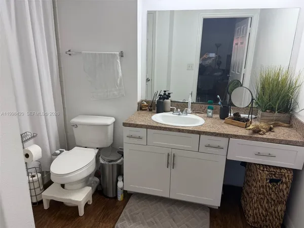 a bathroom with a toilet a sink and a mirror