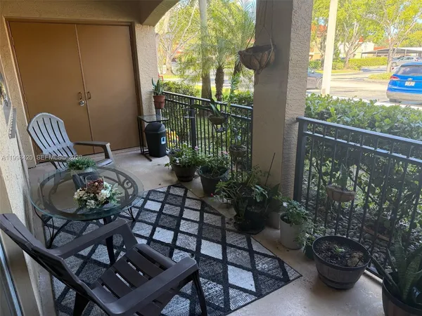 a view of a balcony with chairs and plants