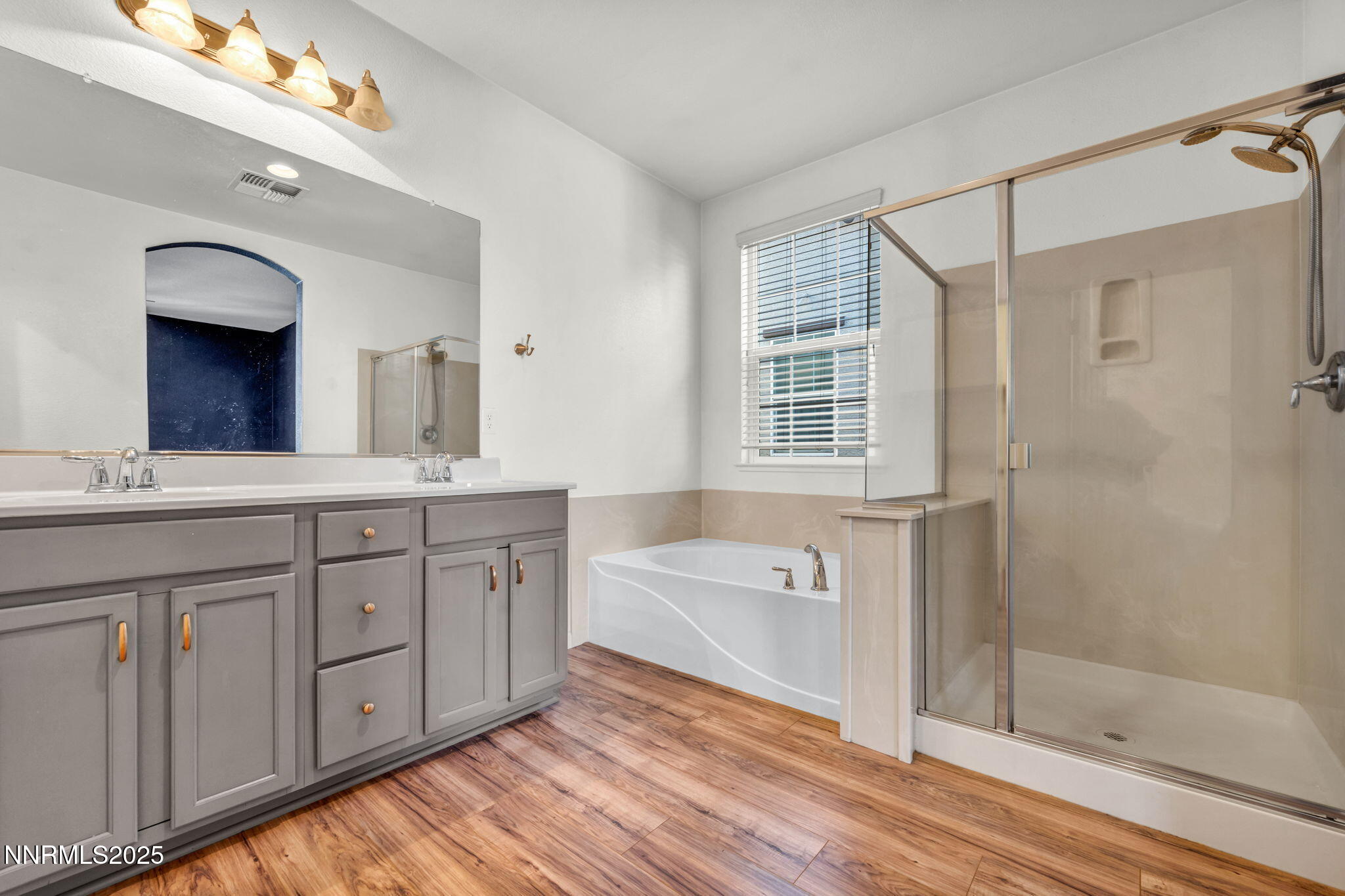1864 Wind Ranch Road, Unit C Reno, NV 89521 - Photo 16 of 49 a spacious bathroom with double vanity a sink a mirror a bathtub and next to a window