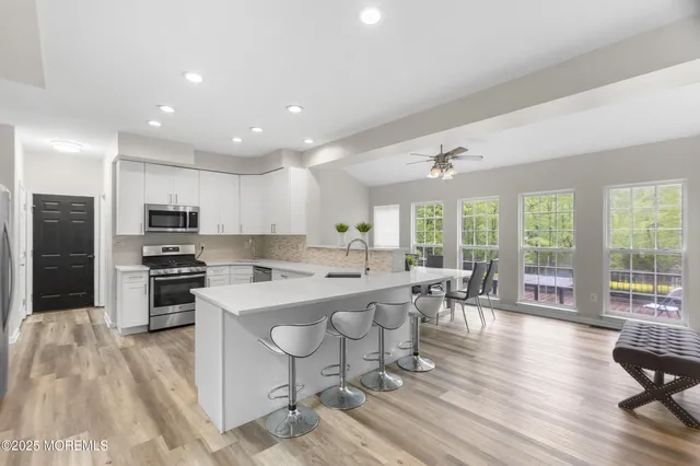 a kitchen with stainless steel appliances a refrigerator a stove top oven a sink and cabinets