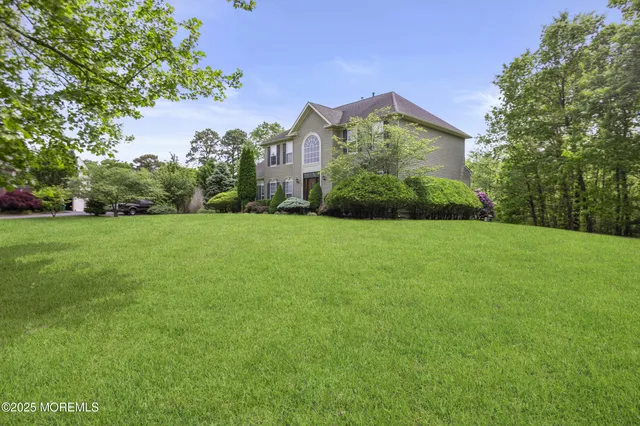 a front view of a house with yard and green space
