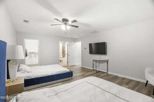 a view of a room with wooden floor and ceiling fan