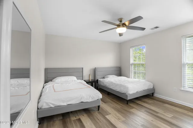 a spacious bedroom with a bed and painting on the wall
