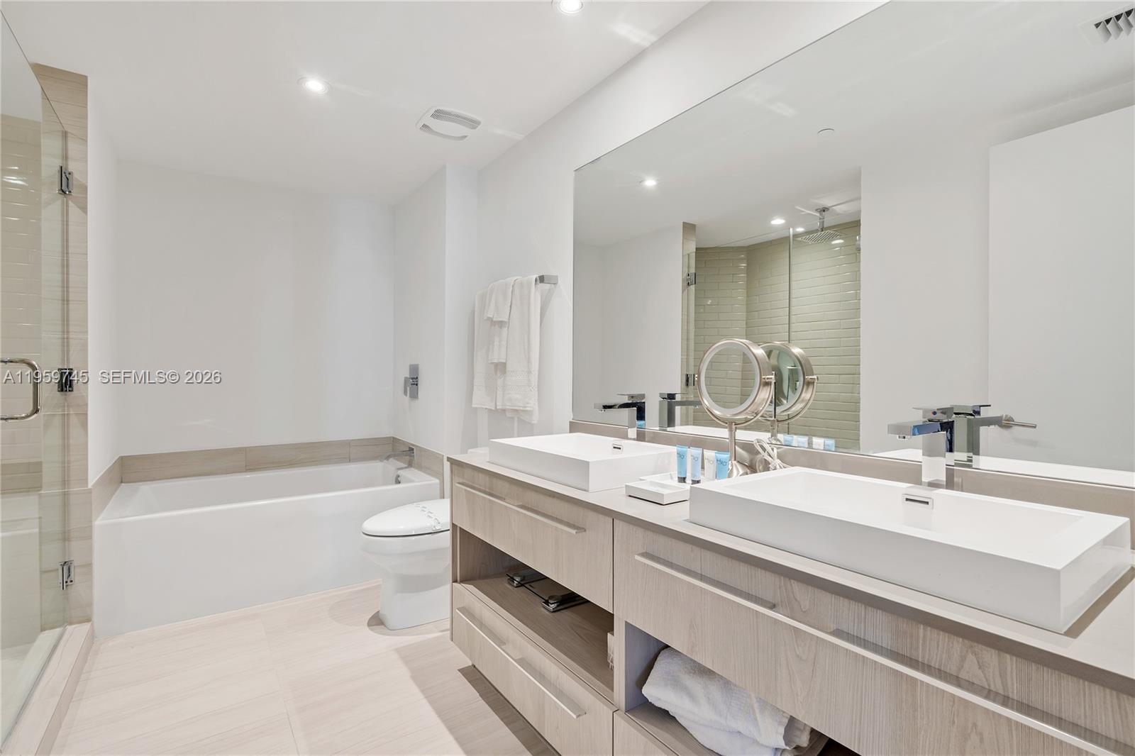 4010 South Ocean Drive, Unit R2301 Hollywood, FL 33019 - Photo 18 of 33 a bathroom with a double vanity sink toilet mirror and bathtub