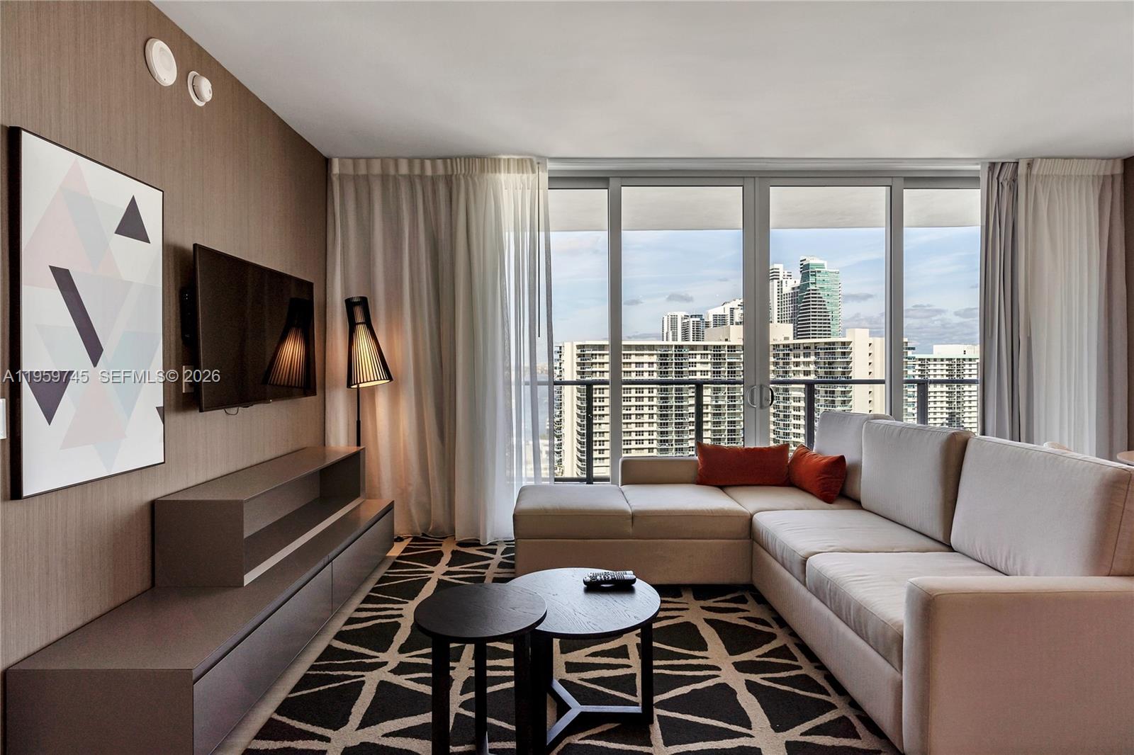 4010 South Ocean Drive, Unit R2301 Hollywood, FL 33019 - Photo 3 of 33 a living room with furniture and a flat screen tv