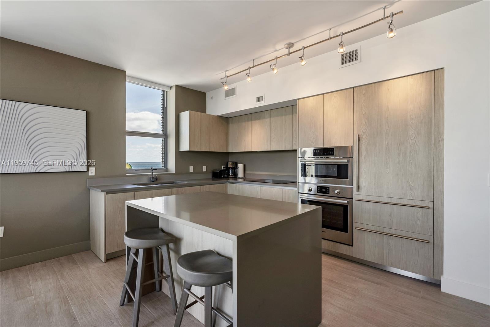 4010 South Ocean Drive, Unit R2301 Hollywood, FL 33019 - Photo 4 of 33 a kitchen with stainless steel appliances granite countertop a sink a stove a refrigerator and island with wooden floor