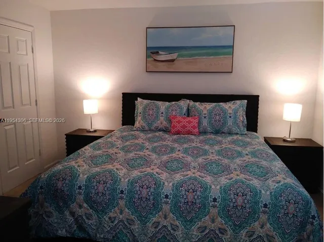 a bedroom with a bed and painting on the wall