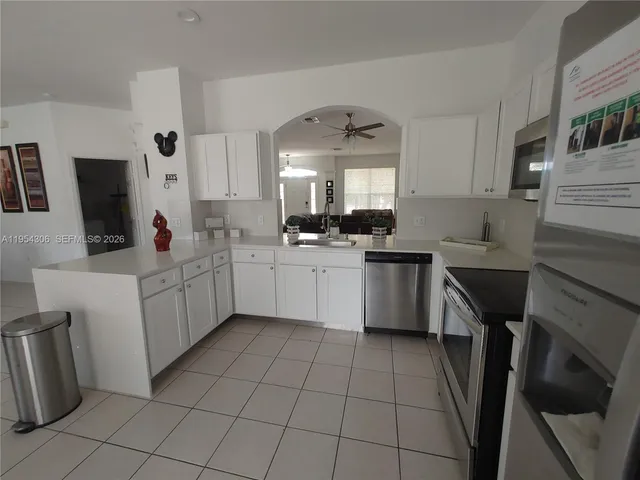a front view of a house with a yard and potted plants