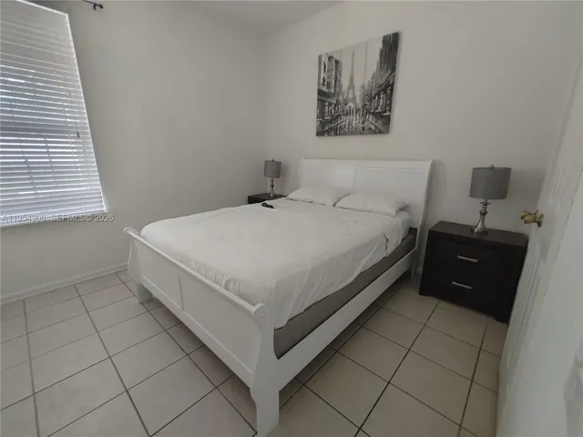 a large bed sitting in a bedroom next to a window