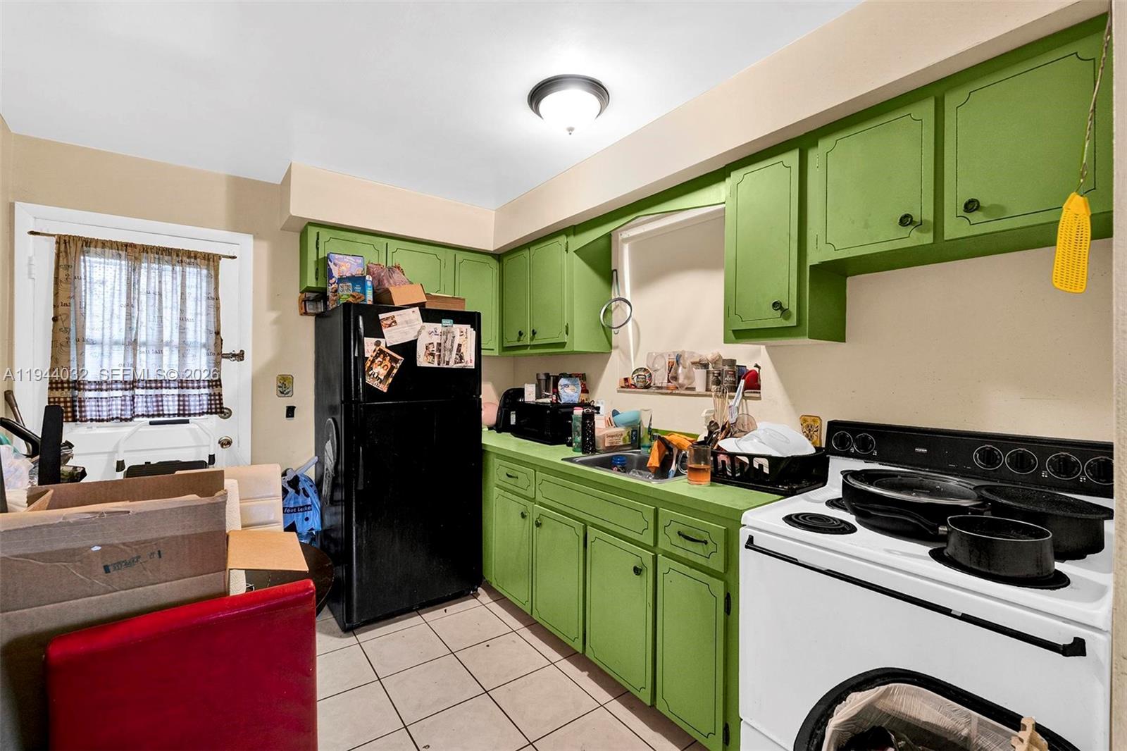 1900 Northwest 88th Street Miami, FL 33147 - Photo 8 of 31 a kitchen with a refrigerator and a stove top oven