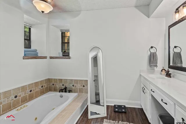 a bathroom with a tub sink and mirror