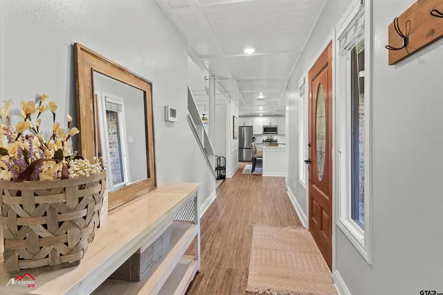 a view of a hallway with wooden floor and stairs