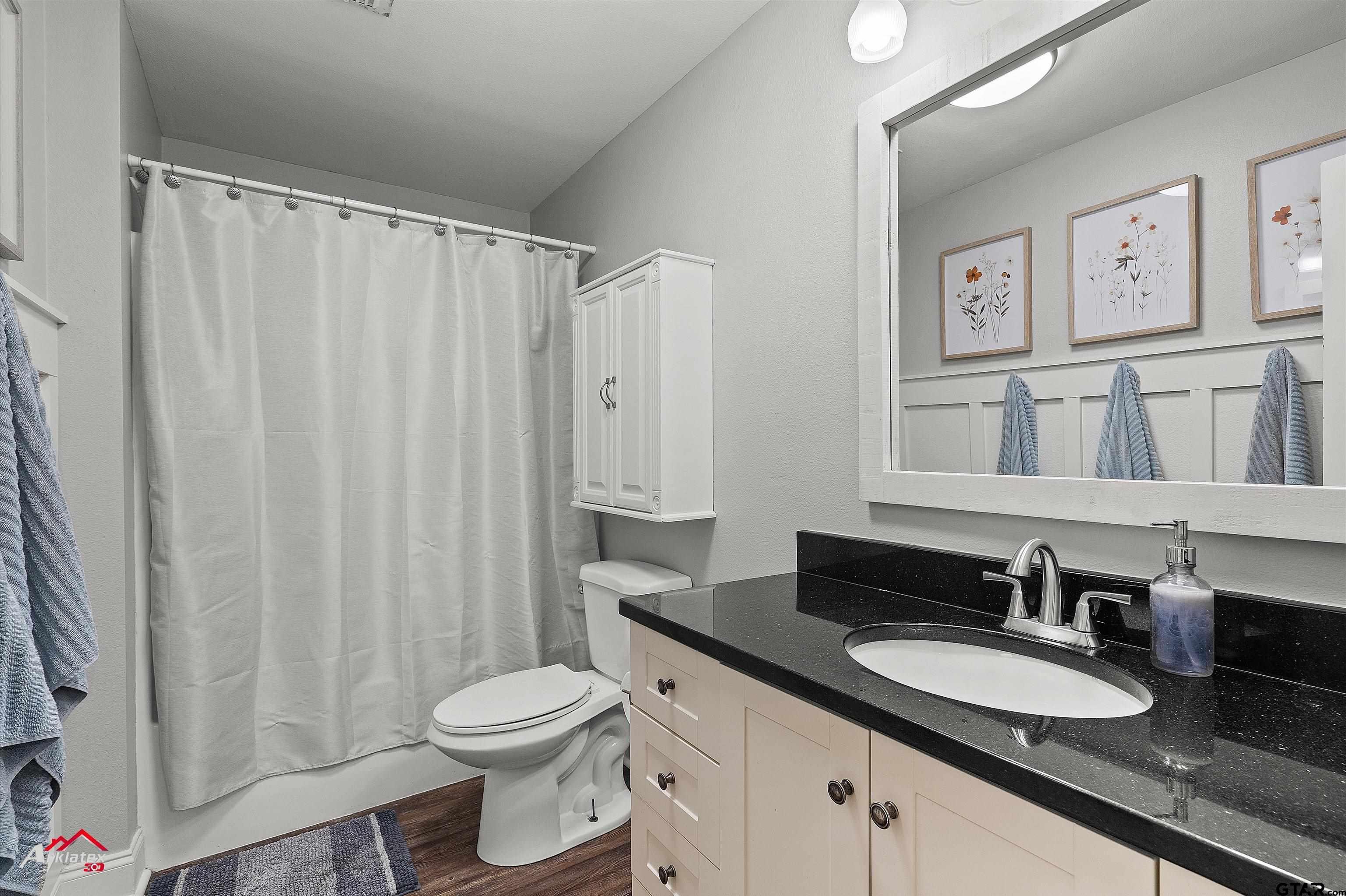 914 Regency Drive Longview, TX 75604 - Photo 23 of 35 a bathroom with a granite countertop sink toilet and a mirror