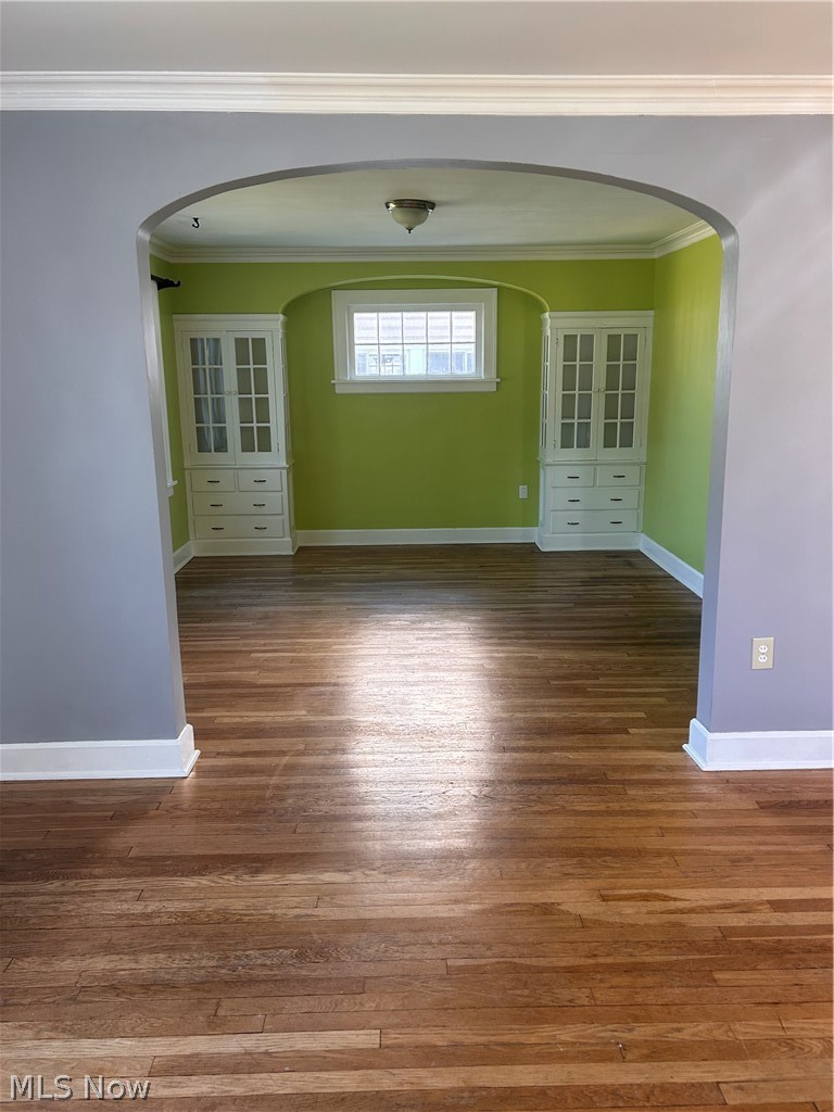 1001 Englewood Road Cleveland Heights, OH 44121 - Photo 6 of 28 Unfurnished room with dark wood-type flooring, arched walkways, and ornamental molding