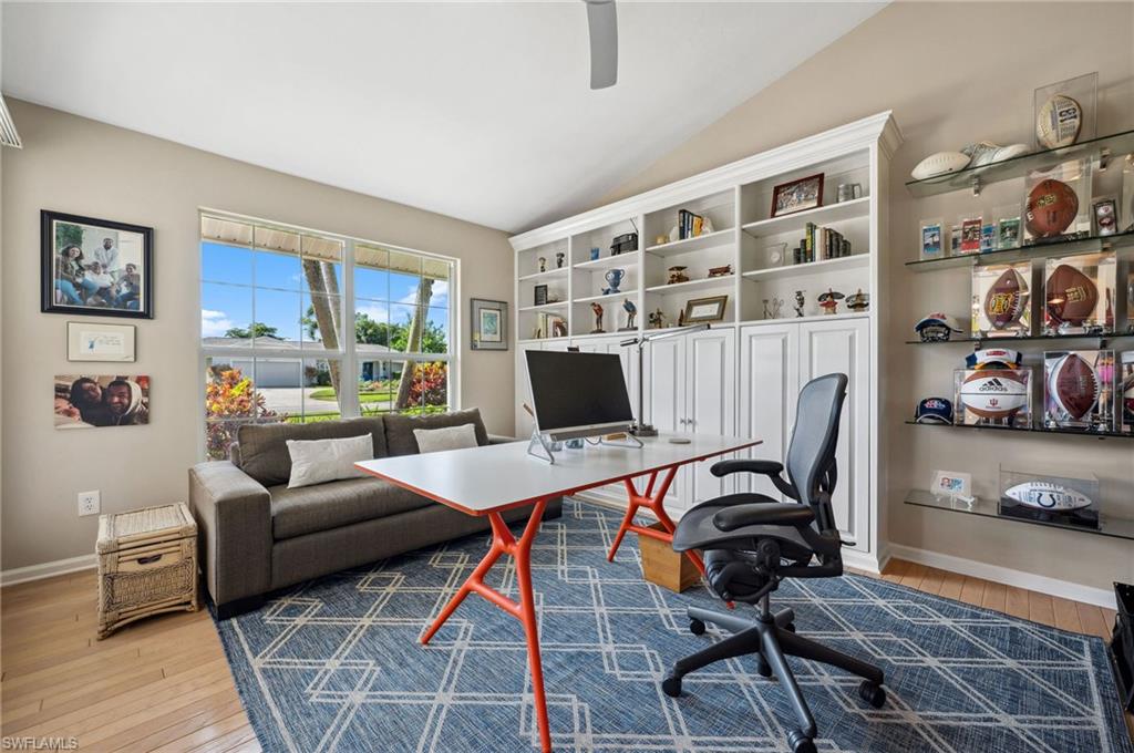 2104 Imperial Golf Course Boulevard Naples, FL 34110 - Photo 12 of 32 a living room with furniture a rug and a bookshelf
