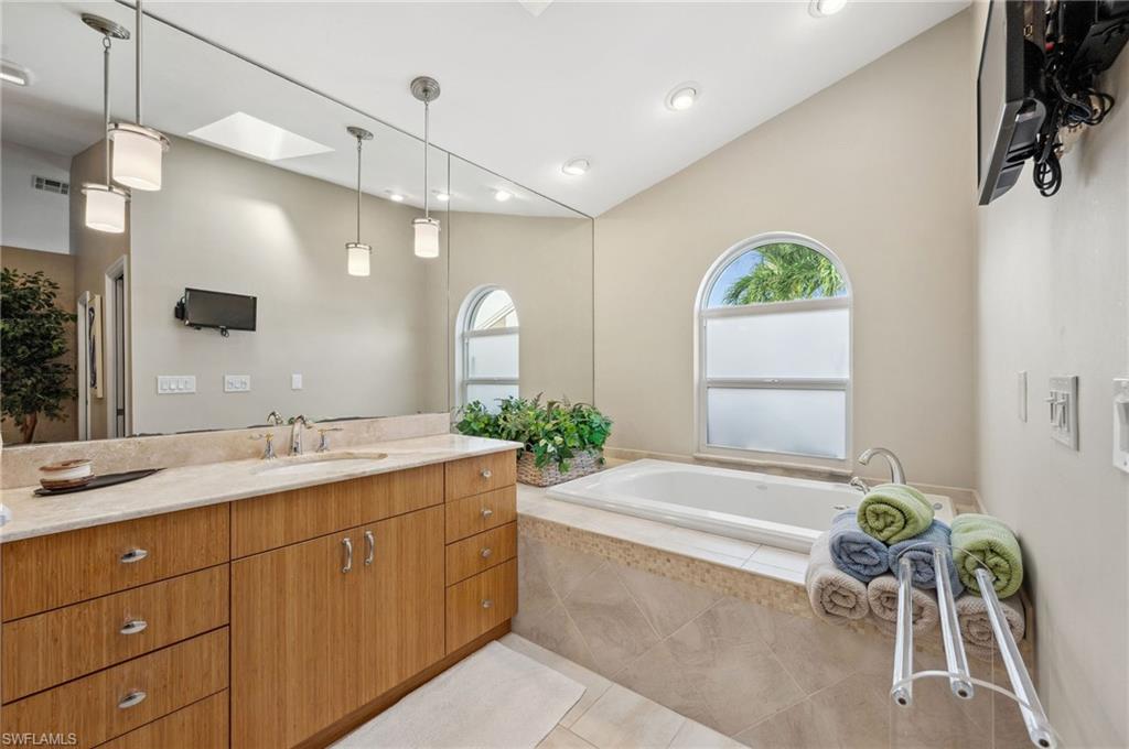 2104 Imperial Golf Course Boulevard Naples, FL 34110 - Photo 17 of 32 a spacious bathroom with a granite countertop sink mirror and bathtub