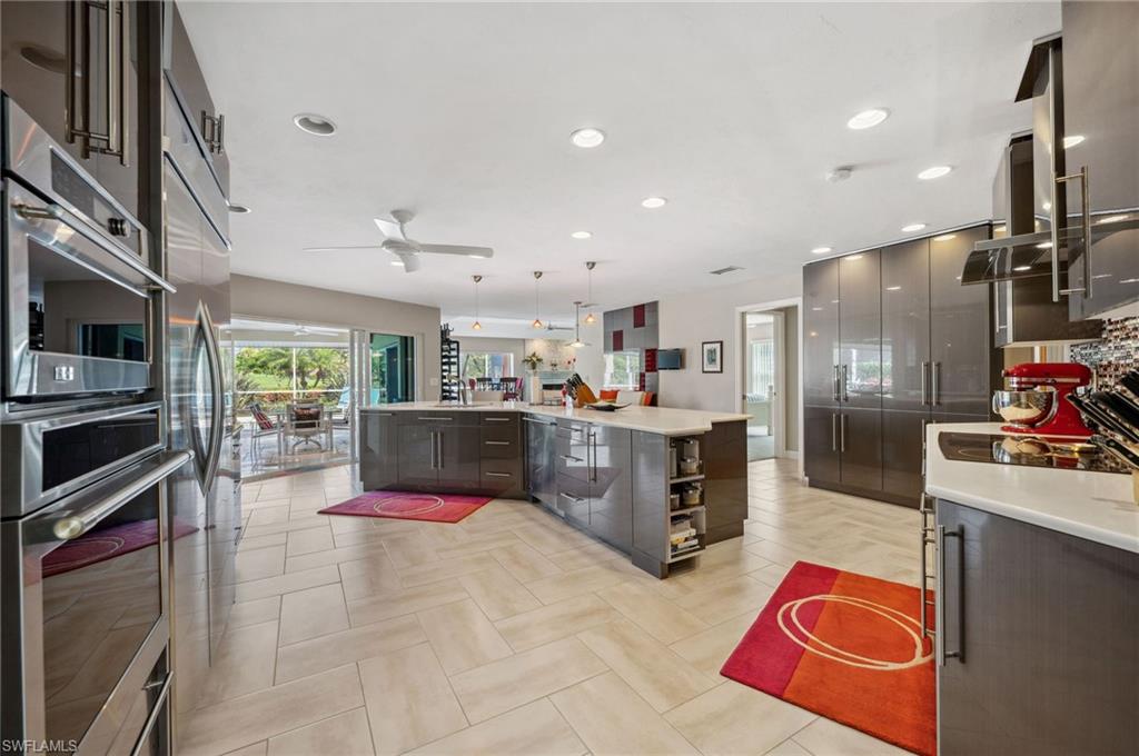 2104 Imperial Golf Course Boulevard Naples, FL 34110 - Photo 5 of 32 a kitchen with stainless steel appliances kitchen island granite countertop a refrigerator and a stove