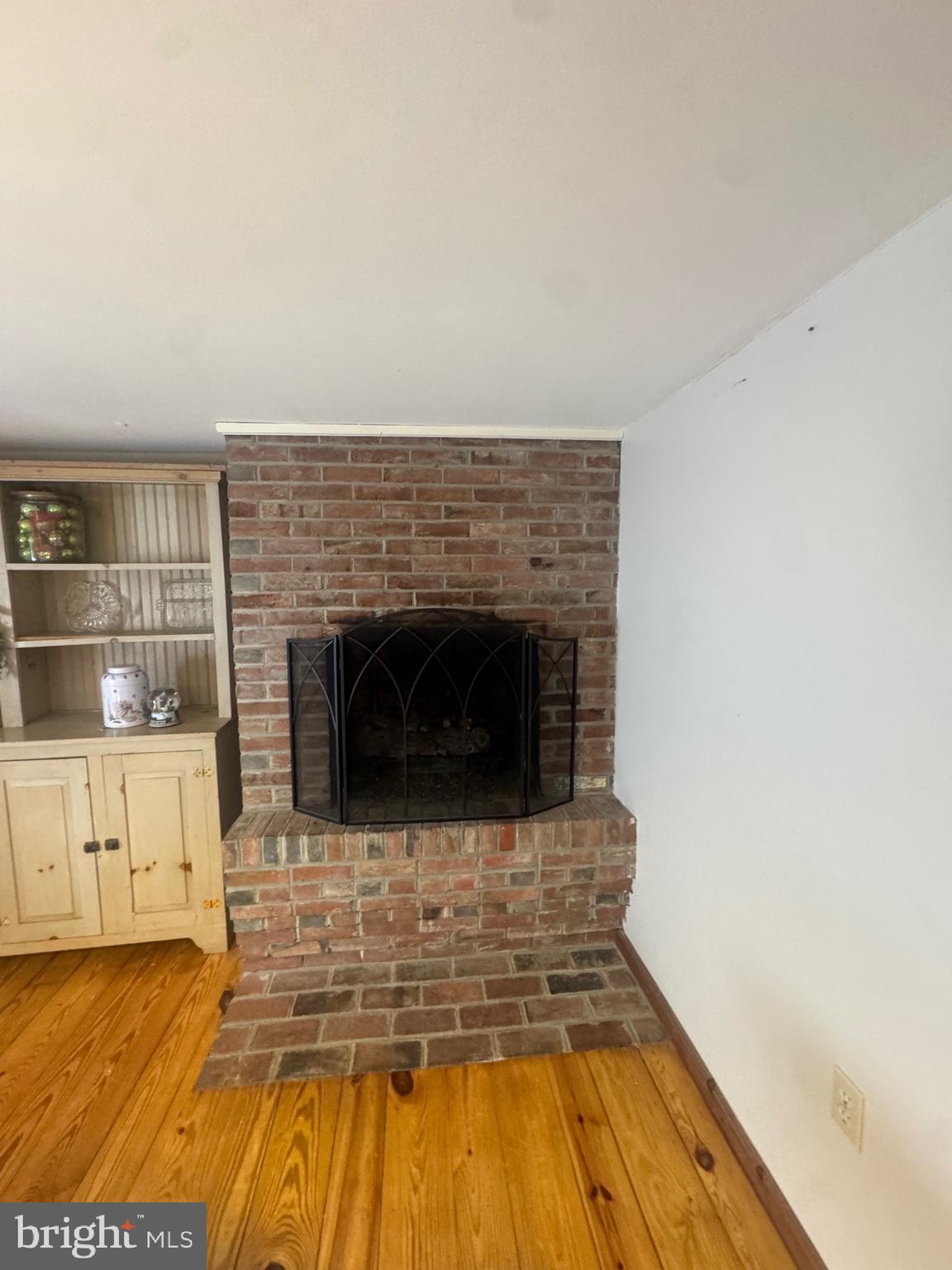 18 Market Street Salem, NJ 08079 - Photo 12 of 39 a living room with a fireplace and a wooden floor