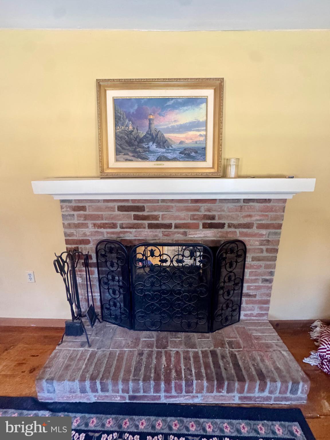 18 Market Street Salem, NJ 08079 - Photo 15 of 39 a fireplace with a clock on wooden floor