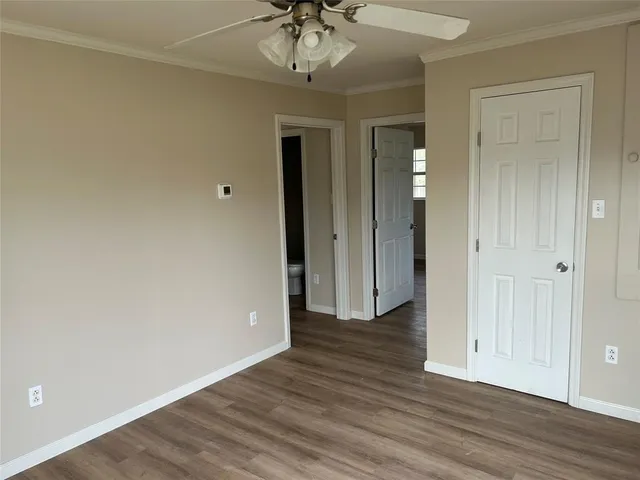 a view of a room with wooden floor and a ceiling fan