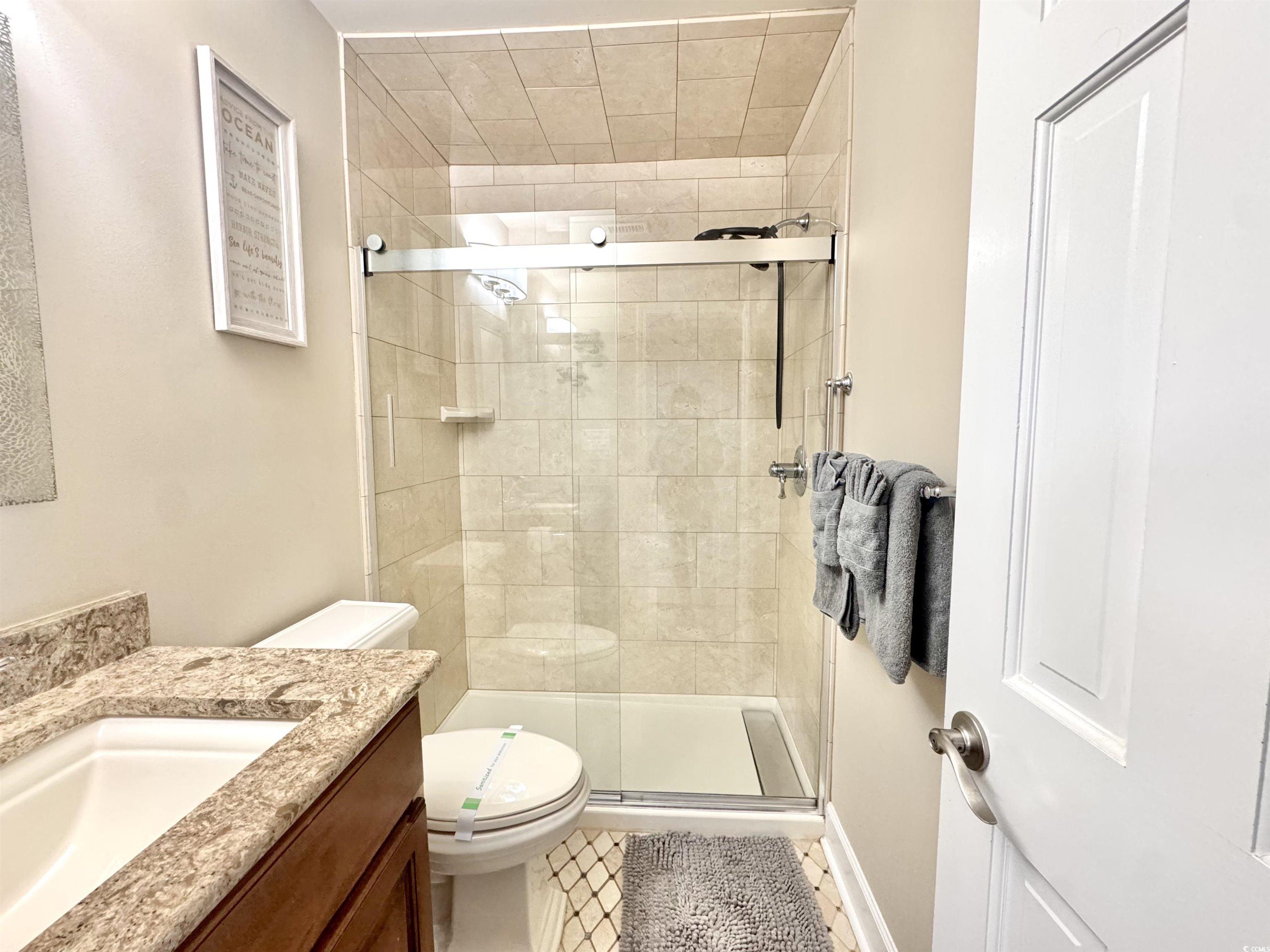 1111 North Ocean Boulevard, Unit 305 Surfside Beach, SC 29575 - Photo 25 of 38 Bathroom with granite top vanity and custom tiled walk-in shower