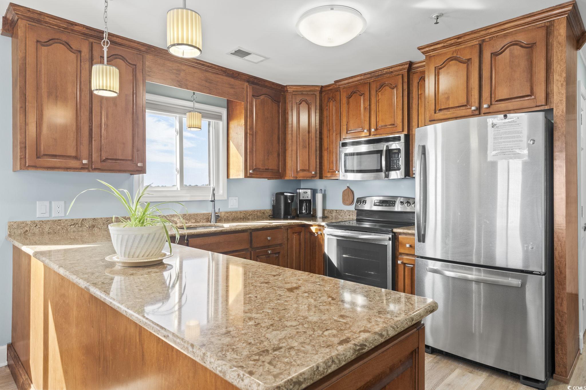 1111 North Ocean Boulevard, Unit 305 Surfside Beach, SC 29575 - Photo 4 of 38 Kitchen with custom cabinets, granite countertops, stainless steel appliances.