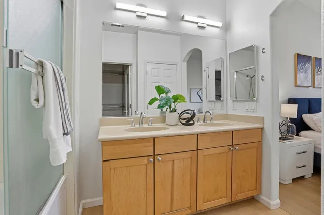 a bathroom with a double vanity sink mirror and shower
