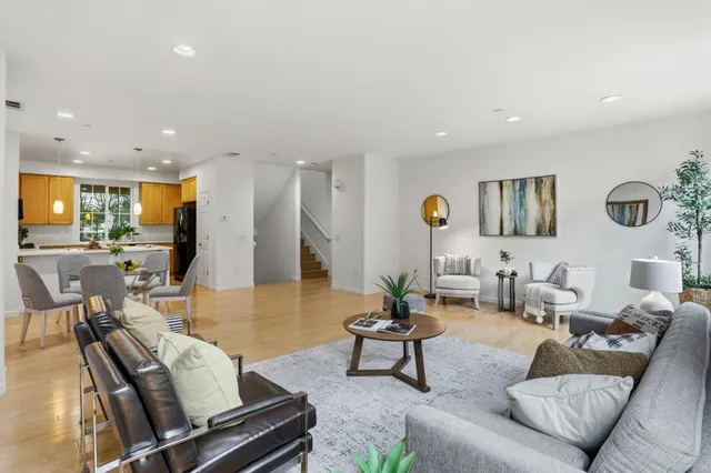 a living room with furniture kitchen view and a table