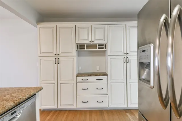 a kitchen with white cabinets and refrigerator