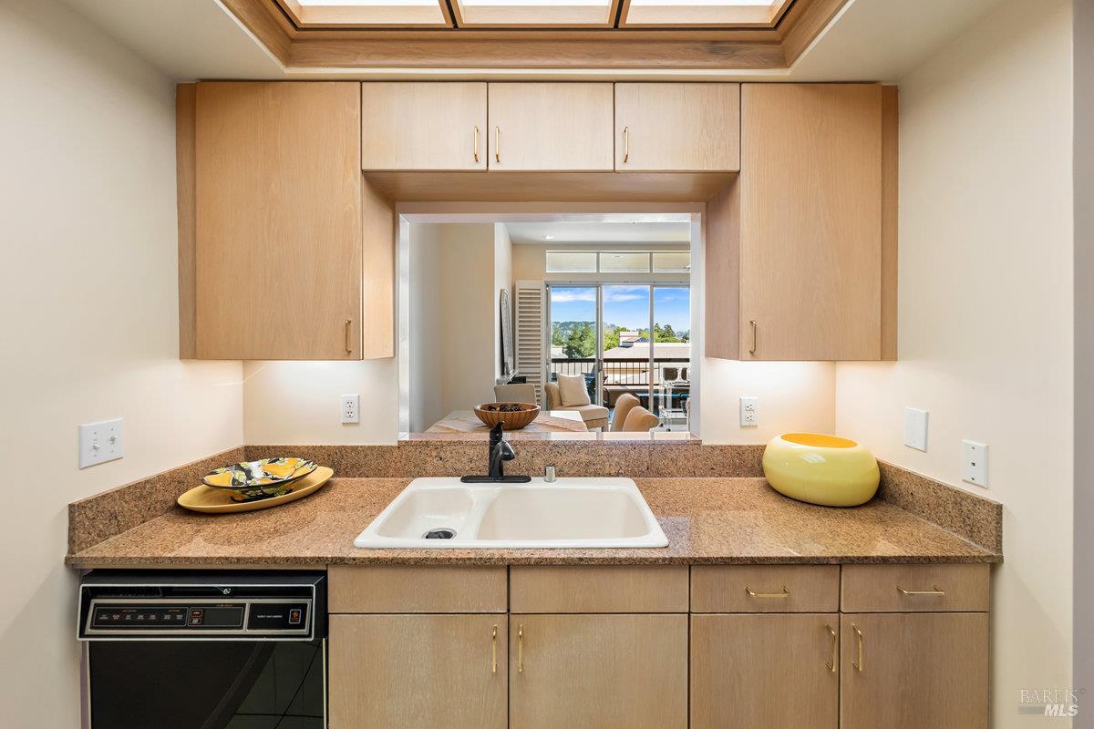 400 Deer Valley Road, Unit 4D San Rafael, CA 94903 - Photo 11 of 50 Dual sink with disposal, dishwasher, granite counters, and under cabinet lighting.