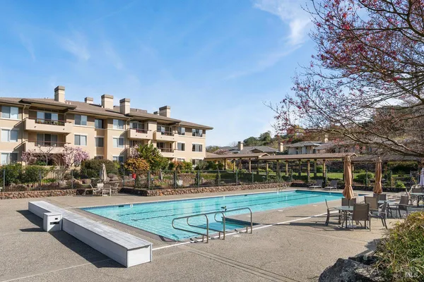 a view of a patio with chairs and a table with swimming pool