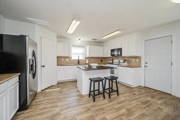 a kitchen with a table chairs and chandelier