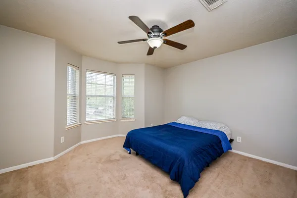 a view of wooden floor and a chandelier fan in a room