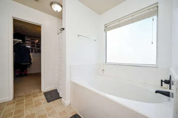 a bathroom with a double vanity sink a mirror and a bathtub