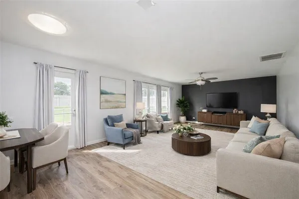 a living room with furniture a flat screen tv and a large window