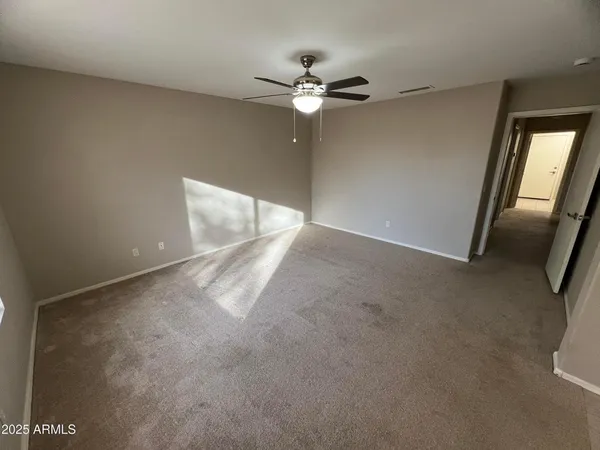 a view of a room with a ceiling fan and window