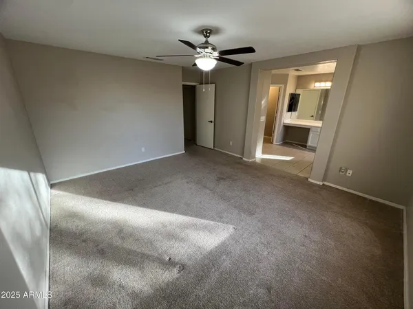 a view of an empty room with a ceiling fan