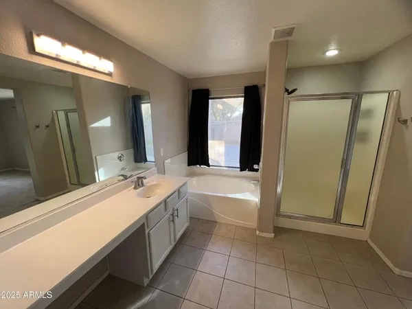 a spacious bathroom with a bathtub sink and mirror