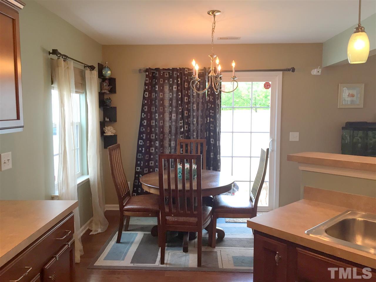 1925 Raj Drive Durham, NC 27703 - Photo 10 of 25 Open kitchen and dining area with lots of natural light. Sliding glass door leads to patio and fenced backyard. Beautiful hardwood floors!