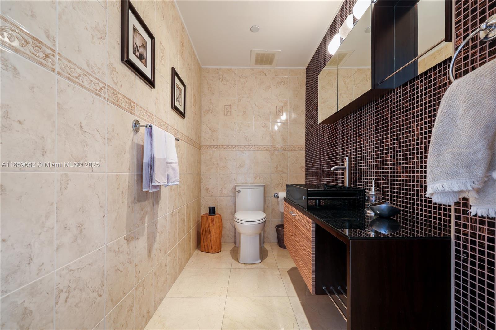 110 Hendricks Isle, Unit 13 Fort Lauderdale, FL 33301 - Photo 49 of 80 a bathroom with a granite countertop sink a toilet and a shower