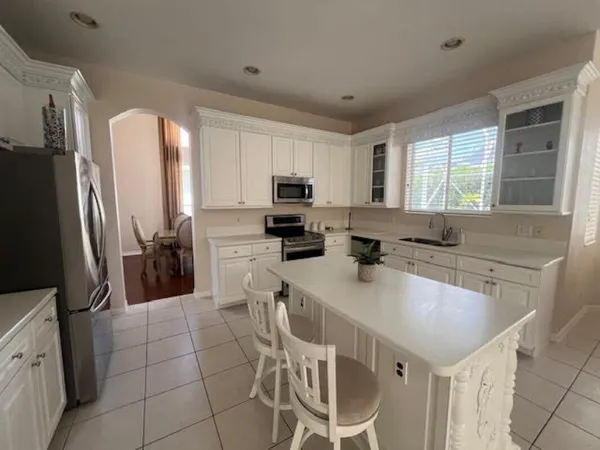 a kitchen with a sink a counter top space cabinets stainless steel appliances and a window