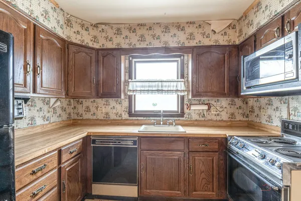 a kitchen with stainless steel appliances granite countertop a sink stove and cabinets