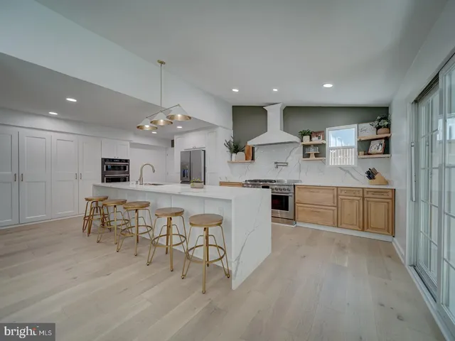 a walk in closet with wooden floor and a bathroom