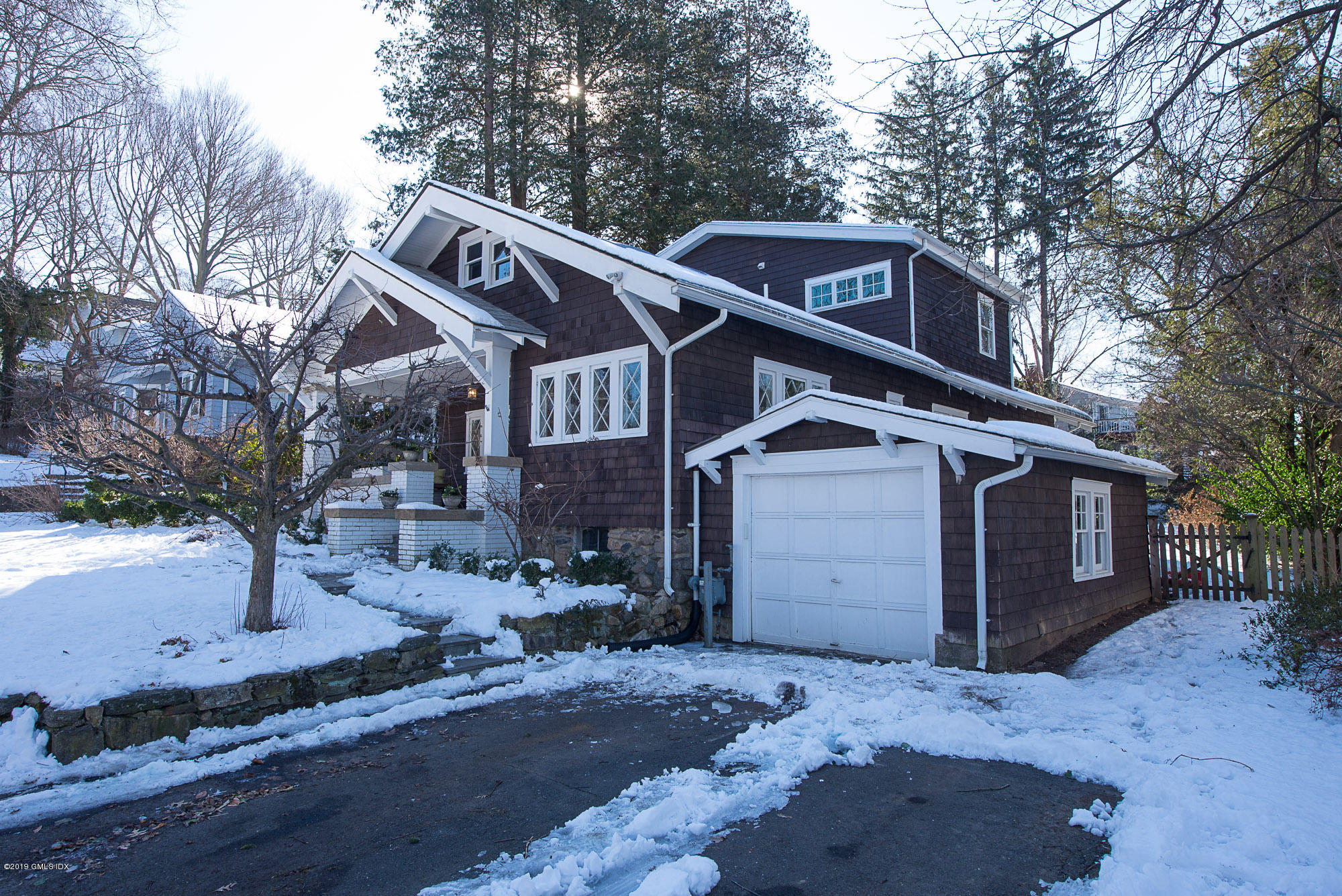 28 Chapel Lane Riverside, CT 06878 - Photo 8 of 38 a front view of a house with a yard covered with snow