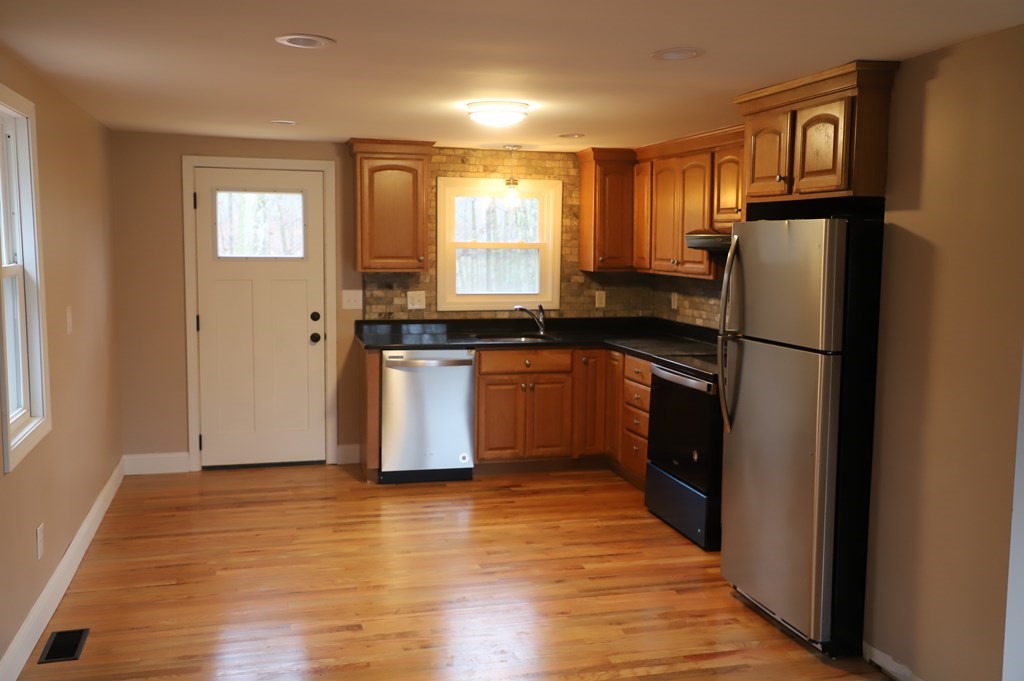 5 Hunt Road North Brookfield, MA 01535 - Photo 5 of 26 a kitchen with stainless steel appliances granite countertop a refrigerator a sink dishwasher and wooden cabinets with wooden floor