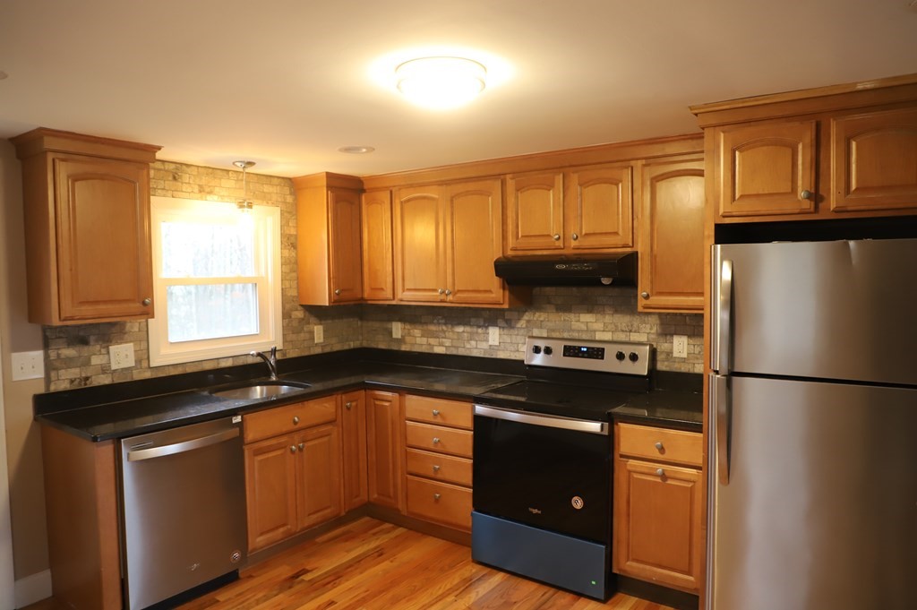 5 Hunt Road North Brookfield, MA 01535 - Photo 6 of 26 a kitchen with stainless steel appliances granite countertop a refrigerator a sink dishwasher a stove and white countertops with wooden floor