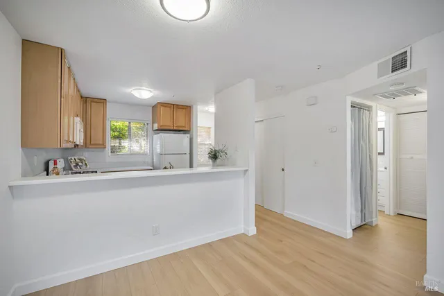 a view of a kitchen with a sink and a refrigerator