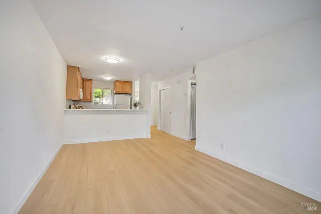 a view of a kitchen with wooden floor and a window