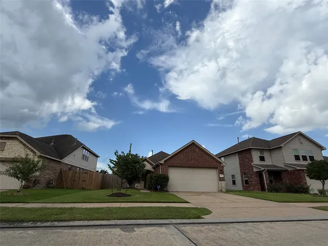 a front view of a house with a garden and trees